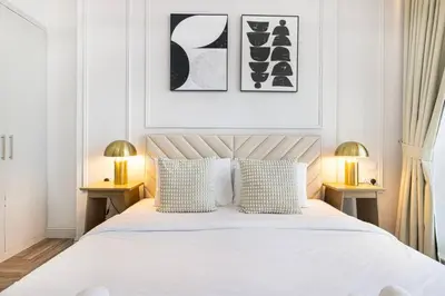 a bedroom with a large white bed with two lamps at StayMada - Torch Tower Elegant Marina Retreat in Dubai