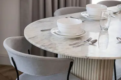 a marble table with plates and bowls on it at StayMada - Torch Tower Elegant Marina Retreat in Dubai