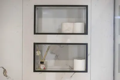 two framed mirrors on a wall with toilet paper at StayMada - Torch Tower Elegant Marina Retreat in Dubai