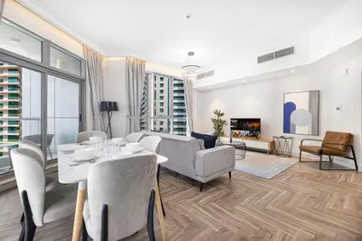 a living room with a table and chairs and a couch at StayMada - Torch Tower Stunning Balcony City Views in Dubai
