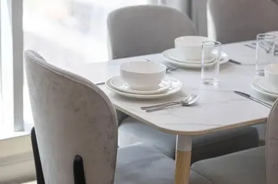 a white table with plates and bowls on it at StayMada - Torch Tower Stunning Balcony City Views in Dubai