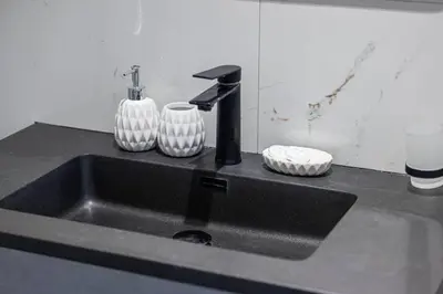 a kitchen sink with a faucet and two vases at StayMada - Torch Tower Stunning Balcony City Views in Dubai