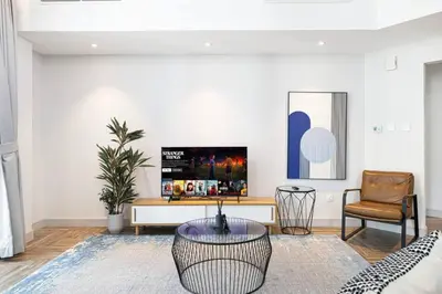 a living room with a table and a chair at StayMada - Torch Tower Stunning Balcony City Views in Dubai