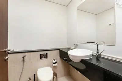 a bathroom with a sink and a toilet and a mirror at Comfy 1BR apartment in Sport City in Dubai