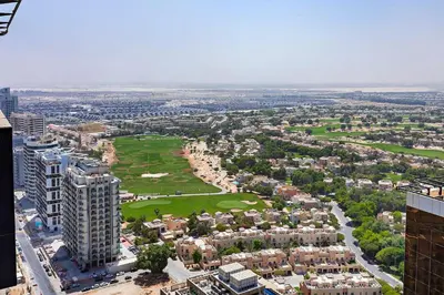 an aerial view of a city with trees and buildings at Comfy 1BR apartment in Sport City in Dubai