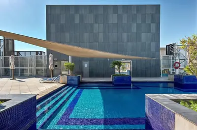 a swimming pool in front of a building at Comfy 1BR apartment in Sport City in Dubai
