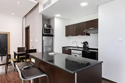 a kitchen with a black counter top in a room at Comfy 1BR apartment in Sport City in Dubai