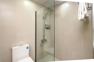 a shower with a glass door next to a toilet at Vacay Lettings - Lake Terrace JLT - Walk to Metro in Dubai