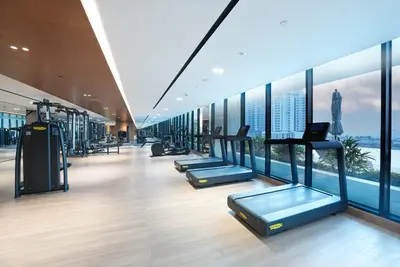 a gym with a row of treadmills and windows at Premium Stay at High-Floor Trillionaire Studio in Dubai