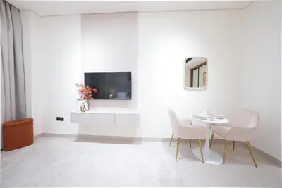 a white living room with a table and chairs at Premium Stay at High-Floor Trillionaire Studio in Dubai
