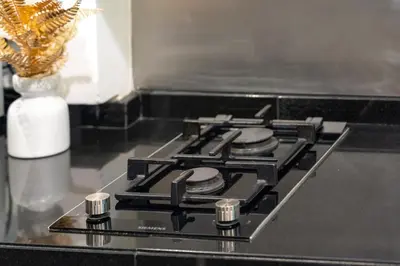 a black stove top oven with a vase on a counter at DAMAC Cour Jardin - Pool & Gym - Free Parking in Dubai