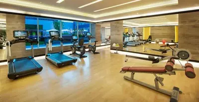 a gym with several cardio machines in a room at DAMAC Cour Jardin - Pool & Gym - Free Parking in Dubai