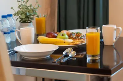 a breakfast table with a plate of fruit and juice at DAMAC Cour Jardin - Pool & Gym - Free Parking in Dubai