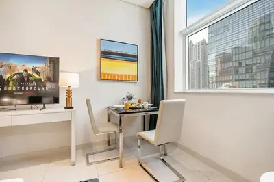 a room with a desk with chairs and a window at DAMAC Cour Jardin - Pool & Gym - Free Parking in Dubai