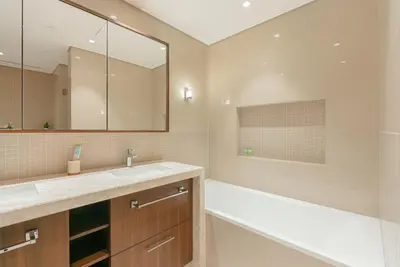a bathroom with a sink and a tub and a mirror at Luxury 2-Bedroom Apartment with Stunning City Views By Norbu Holiday Homes in Dubai