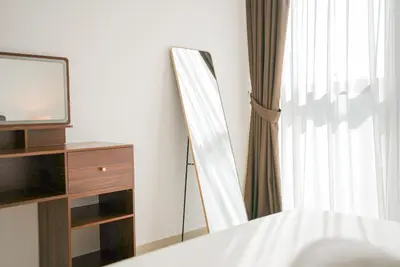 a bedroom with a mirror and a dresser and a television at Luxury 2-Bedroom Apartment with Stunning City Views By Norbu Holiday Homes in Dubai