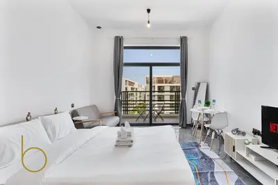 a bedroom with a white bed and a balcony at Bookable Studio Room Joya Blanca,Arjan with Tennis court access in Dubai