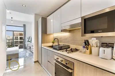 a kitchen with a sink and a stove top oven at Bookable Studio Room Joya Blanca,Arjan with Tennis court access in Dubai