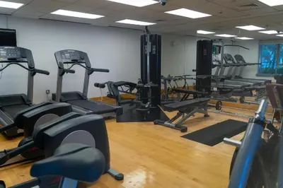 a gym with several tread machines in a room at Chic Downtown Studio Few Steps to Burj Khalifa by Simply Comfort in Dubai