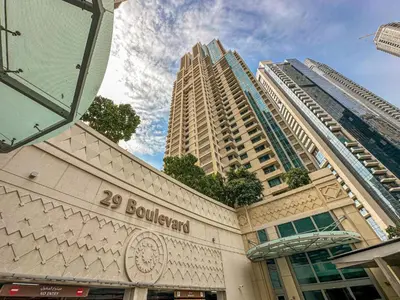 a building with two tall buildings in the background at Chic Downtown Studio Few Steps to Burj Khalifa by Simply Comfort in Dubai