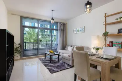 a living room with a couch and a table and a dining room at VayK - Great 1BR in Downtown near Burj Khalifa in Dubai