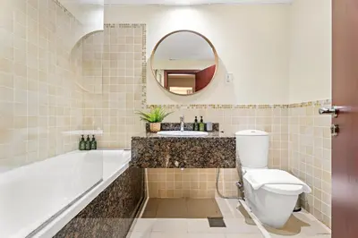 a bathroom with a tub and a toilet and a sink at VayK - Beautiful 1BR in JBR near the Beach in Dubai