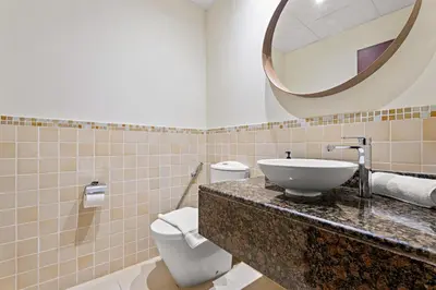 a bathroom with a sink and a toilet and a mirror at VayK - Beautiful 1BR in JBR near the Beach in Dubai