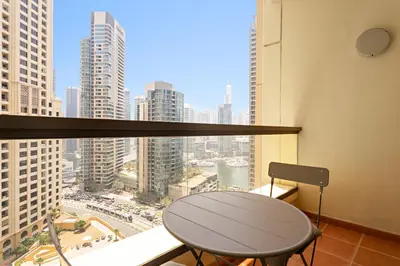 a table and chair in a room with a view of a city at VayK - Beautiful 1BR in JBR near the Beach in Dubai