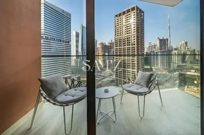 a balcony with two chairs and a table and a city at Studio Escape - Unit 1805 - Near Downtown! in Dubai
