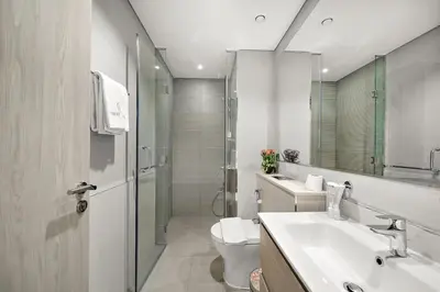 a bathroom with a toilet and a sink and a shower at FIRST CLASS 1BR Pool View & Prime Location in Dubai