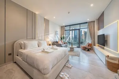 a bedroom with a large bed and a television at Modern Studio - Unit 1705 - Near Downtown in Dubai