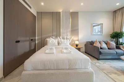 a bedroom with a large white bed and a couch at Modern Studio - Unit 1705 - Near Downtown in Dubai