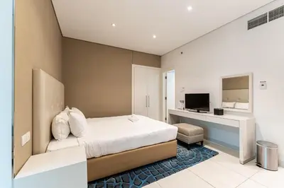 a bedroom with a bed and a desk and a television at HAVN - Studio in Cour Jardin, Business Bay in Dubai
