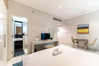 a bedroom with a bed and a desk and a television at HAVN - Studio in Cour Jardin, Business Bay in Dubai