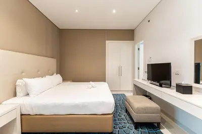 a bedroom with a bed and a flat screen tv at HAVN - Studio in Cour Jardin, Business Bay in Dubai