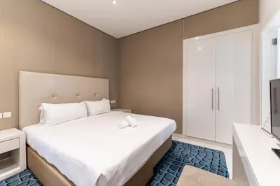 a bedroom with a large bed and a television at HAVN - Studio in Cour Jardin, Business Bay in Dubai