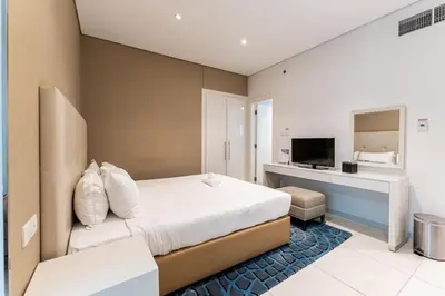 a bedroom with a bed and a desk and a television at HAVN - Studio in Cour Jardin, Business Bay in Dubai