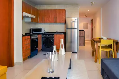 a kitchen with a stainless steel refrigerator and a table at Khayali Marina Holiday Homes Dubai Marina JBR in Dubai