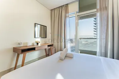 a bedroom with a desk and a bed and a window at Huge Balcony Overlooking Creek Harbour with Glimpses of Burj Khalifa, Just Minutes from Zabeel Stadium, Azizi Aliyah Residence, Al Jaddaf by Deluxe Holiday Homes in Dubai