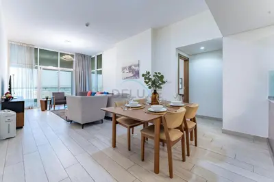 a dining room and living room with a table and chairs at Huge Balcony Overlooking Creek Harbour with Glimpses of Burj Khalifa, Just Minutes from Zabeel Stadium, Azizi Aliyah Residence, Al Jaddaf by Deluxe Holiday Homes in Dubai