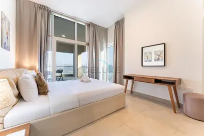 a bedroom with a bed and a desk and a window at Huge Balcony Overlooking Creek Harbour with Glimpses of Burj Khalifa, Just Minutes from Zabeel Stadium, Azizi Aliyah Residence, Al Jaddaf by Deluxe Holiday Homes in Dubai