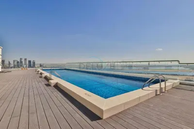a large swimming pool on a boardwalk next to the water at Huge Balcony Overlooking Creek Harbour with Glimpses of Burj Khalifa, Just Minutes from Zabeel Stadium, Azizi Aliyah Residence, Al Jaddaf by Deluxe Holiday Homes in Dubai