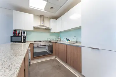 a kitchen with white cabinets and a sink at Huge Balcony Overlooking Creek Harbour with Glimpses of Burj Khalifa, Just Minutes from Zabeel Stadium, Azizi Aliyah Residence, Al Jaddaf by Deluxe Holiday Homes in Dubai