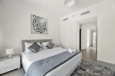 a white bedroom with a large bed and a rug at Chic 3BR in Downtown with Burj Khalifa View in Dubai