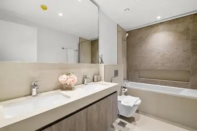a bathroom with two sinks and a tub and a toilet at Chic 3BR in Downtown with Burj Khalifa View in Dubai