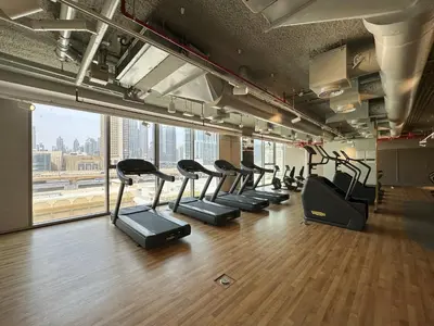 a row of treadmills in a gym with a large window at Chic 3BR in Downtown with Burj Khalifa View in Dubai