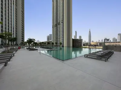 a pool in a city with benches and buildings at Chic 3BR in Downtown with Burj Khalifa View in Dubai