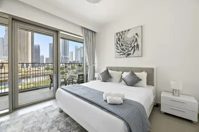 a bedroom with a large bed and a balcony at Chic 3BR in Downtown with Burj Khalifa View in Dubai