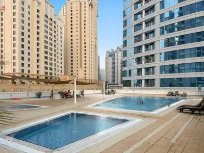 a large pool in a city with tall buildings at FIRST CLASS 2BR Breathtaking Marina Views in Dubai