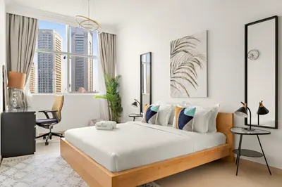 a bedroom with a large bed with white walls and windows at FIRST CLASS 2BR Breathtaking Marina Views in Dubai